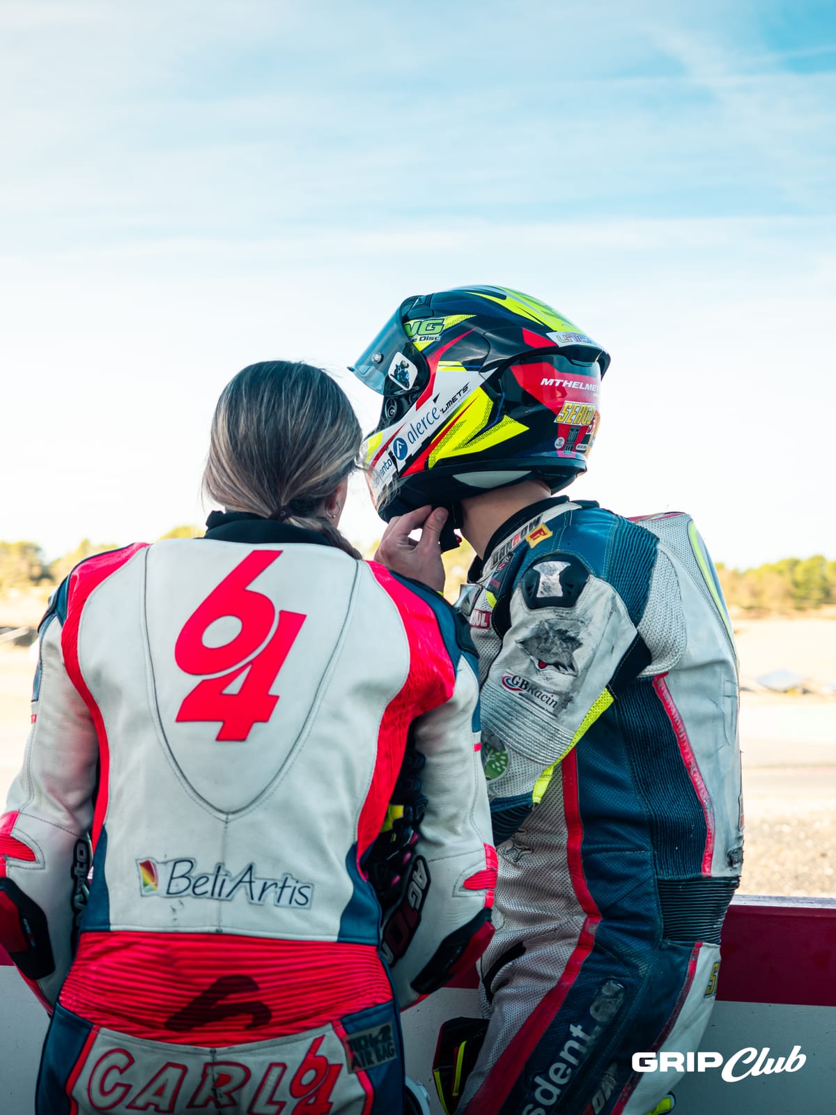 Una piloto y su compañero de equipo se preparan juntos en el muro antes de salir