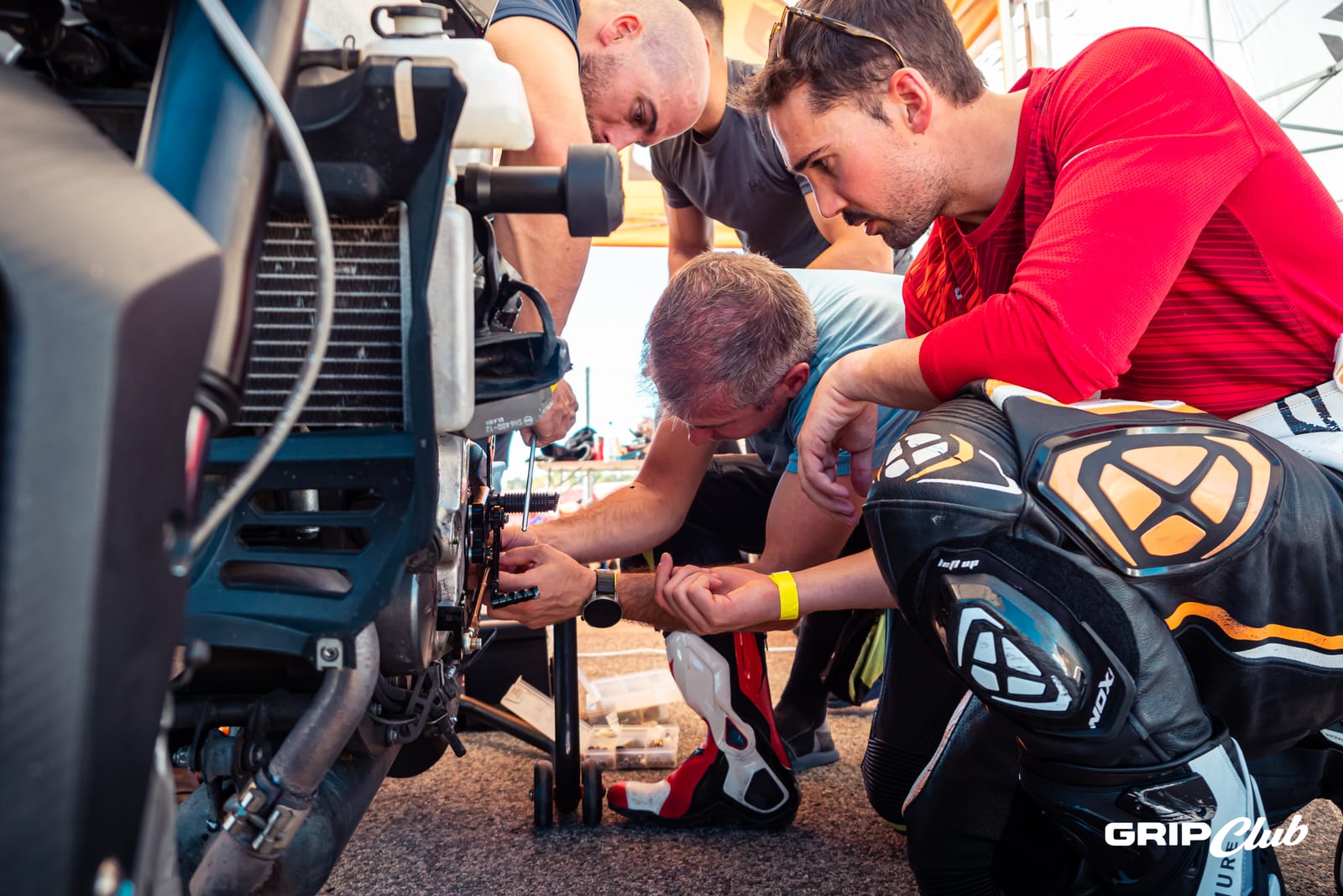 Mecánicos y pilotos trabajan juntos en la moto en la carpa del equipo