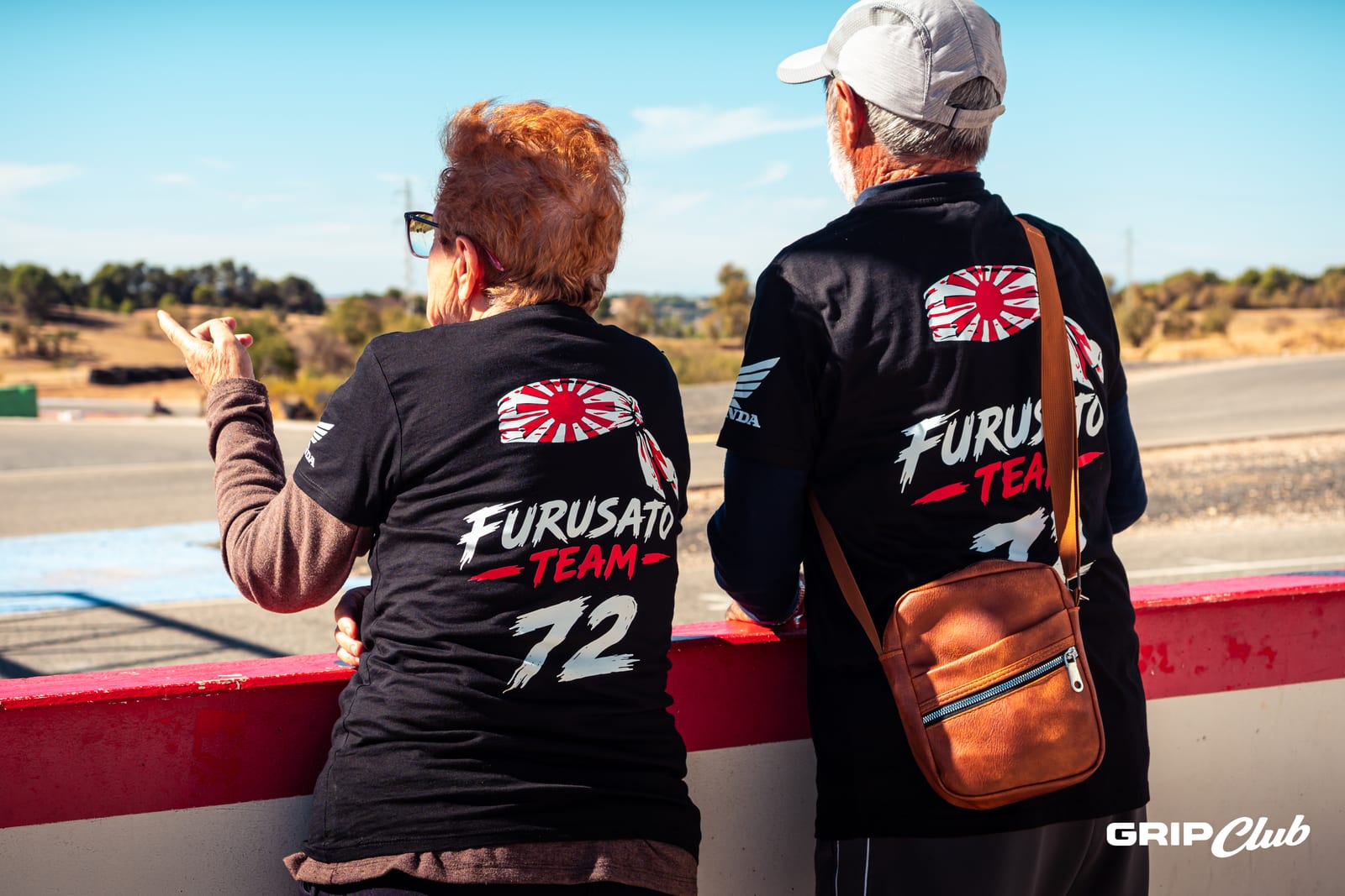 Dos aficionados del Furusato Team siguen la carrera desde el muro