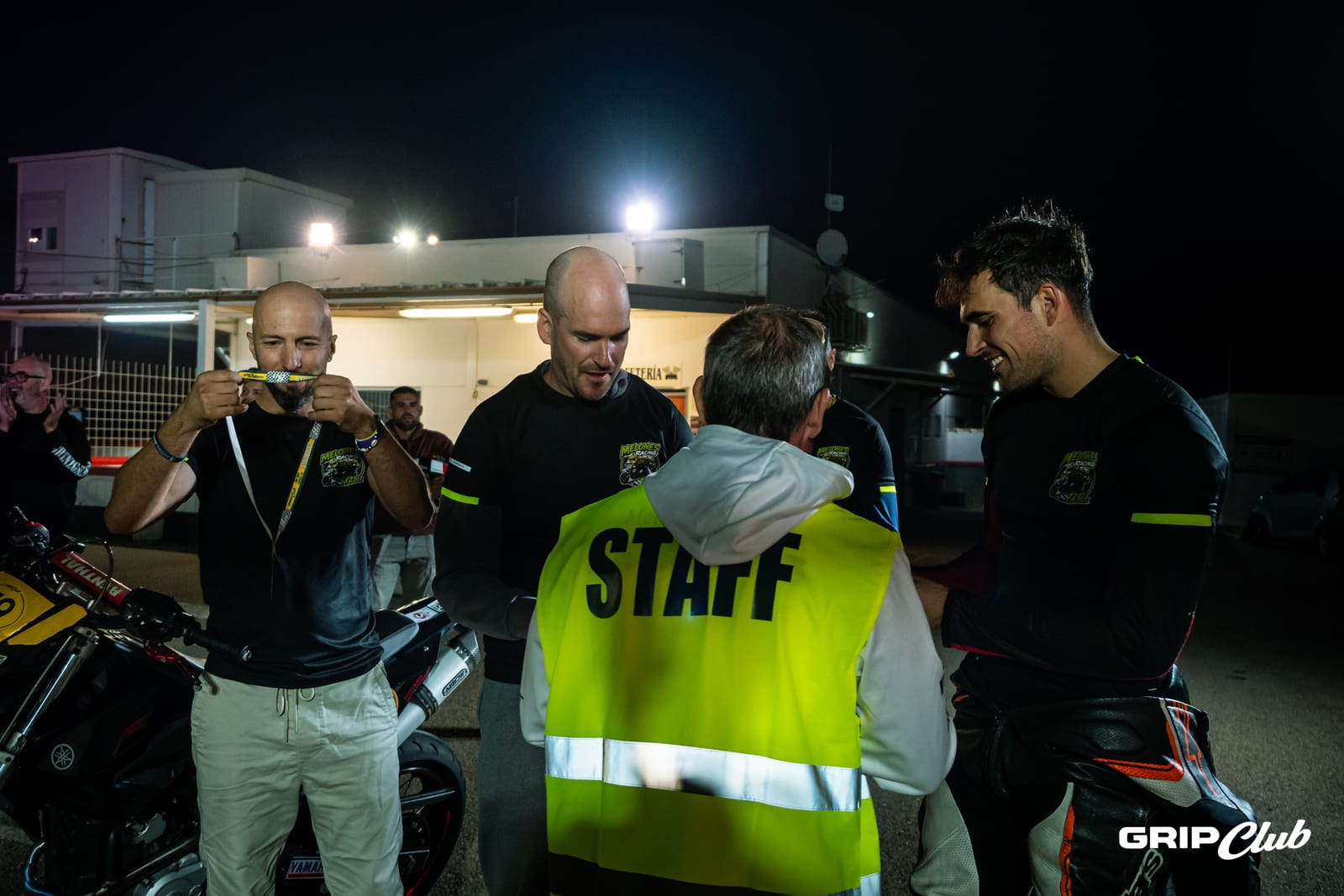 De noche, los pilotos reciben y celebran su medalla de finisher de las 8 Horas